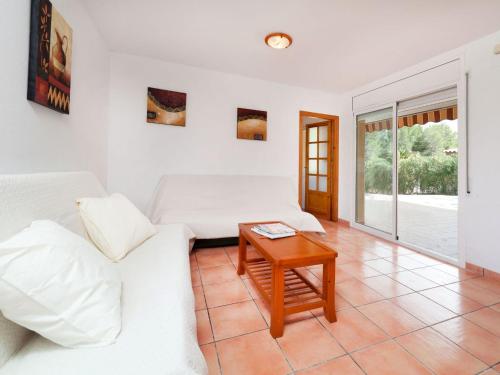 uma sala de estar com um sofá e uma mesa em Villa Mimosa II by Interhome em Les tres Cales