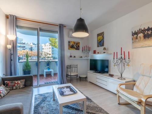 een woonkamer met een bank en een tv bij Apartment SYMAR by Interhome in Roses