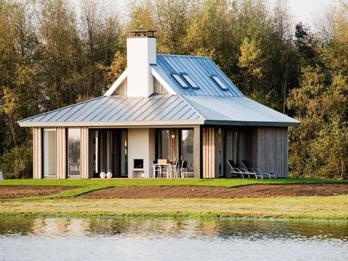 a house on the shore of a body of water at Holiday Home Oesterdam Resort by Interhome in Tholen