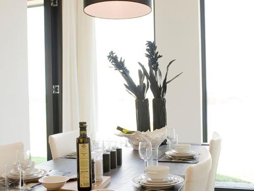 a dining room table with a bottle of wine on it at Holiday Home Oesterdam Resort by Interhome in Tholen