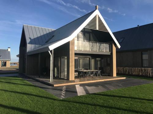 a house with a pitched roof with a table at Holiday Home Oesterdam Resort by Interhome in Tholen