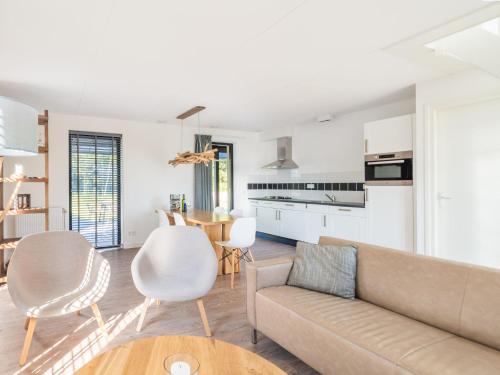 a living room with a couch and chairs and a table at Holiday Home Oesterdam Resort-5 in Tholen