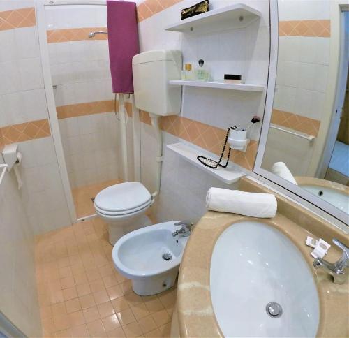 a small bathroom with a toilet and a sink at Hotel Holland in Rimini