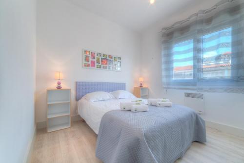 une chambre blanche avec un lit et une fenêtre dans l'établissement IMMOGROOM - Appartment - 1min from the beach - Wifi, à Cannes