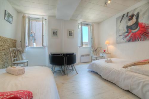 um quarto com 2 camas e uma secretária. em IMMOGROOM Historic Place SUQUET - 8 min PALAIS CONGRESSBEACHES em Cannes