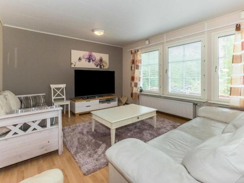 ein Wohnzimmer mit einem Sofa und einem Flachbild-TV in der Unterkunft Holiday Home Käpälämäki by Interhome in Somerniemi