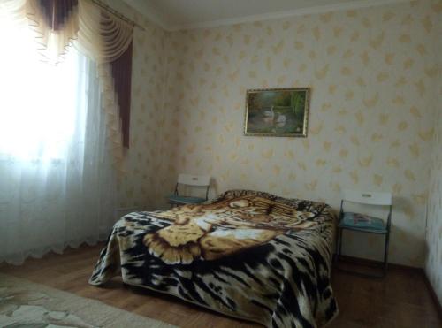 een slaapkamer met een tijgerdeken op een bed bij Гостевой дом на Елисейских полях in Mykolaivka