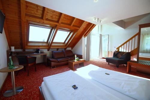 a bedroom with a bed and a living room at ALTE LINDE Landhotel & Restaurant in Aalen