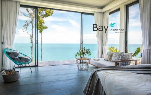 a bedroom with a bed and a view of the ocean at Bay Villas Koh Phangan in Salad Beach
