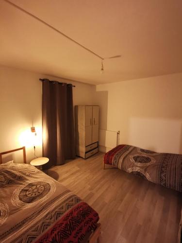 ein Zimmer mit 2 Betten und einer Kommode darin in der Unterkunft Appartement Comfort in Grande-Synthe