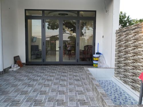 a screened porch with glass doors on a house at VILLA CHÂU ĐỐC in áº¤p VÄ©nh ÃÃ´ng