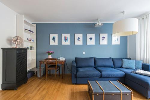 un soggiorno con divano blu e tavolo di Mozart Apartment München a Monaco