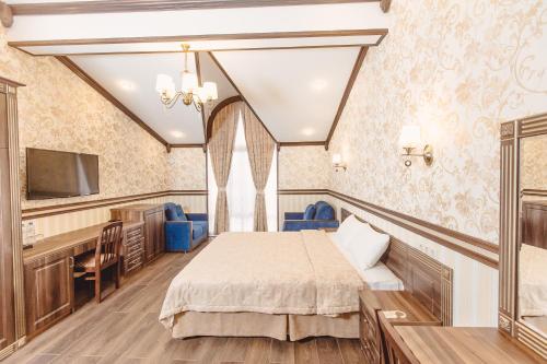 1 dormitorio con 1 cama, escritorio y TV en Villa Polianna en Sochi