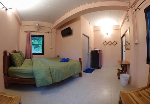 sypialnia z łóżkiem i telewizorem w obiekcie บ้านรักษ์วนา w mieście Khao Kho