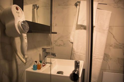 a bathroom with a sink with a phone on the wall at Best Western Hotel Galla in Pristina