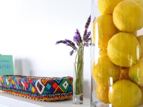 a vase filled with lemons next to a vase of flowers at Abbotts Hill in Malmesbury