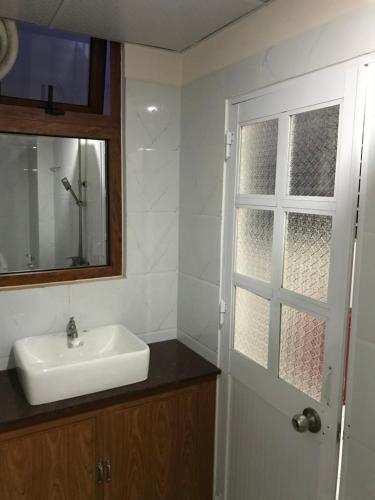 a bathroom with a sink and a mirror and a window at Hoang Anh Hotel in Dĩ An