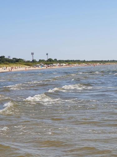 a body of water with a beach in the background at Dzintaru apartaments in Liepāja