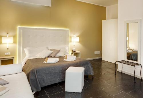 a bedroom with a large bed and a white couch at Villa Principe Di Belmonte in Ispica