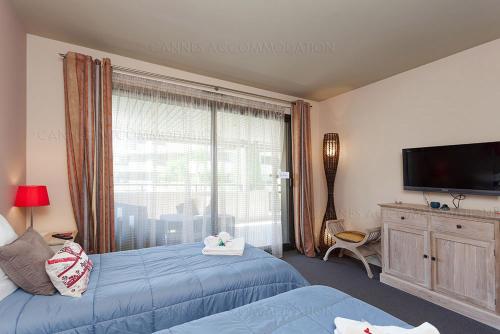 1 Schlafzimmer mit 2 Betten und einem großen Fenster in der Unterkunft gray 3a2 in Cannes