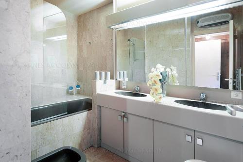 une salle de bain avec deux lavabos et un grand miroir dans l'établissement gray 3a2, à Cannes