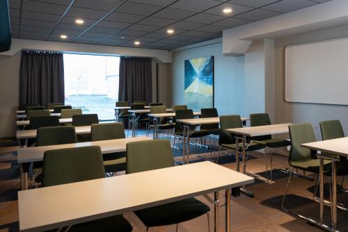 a classroom with tables and chairs and a whiteboard at Quality Hotel Ålesund in Ålesund