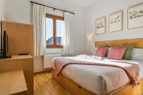 Un dormitorio con una cama grande y una ventana en Luderna - Apartamento Tanau A1 Esquirós en Naut Aran