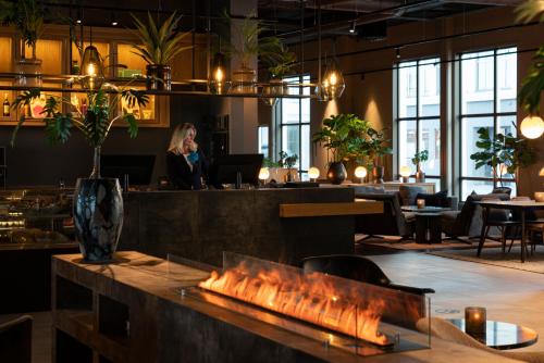 a woman sitting at a table in a restaurant at Quality Hotel Ålesund in Ålesund