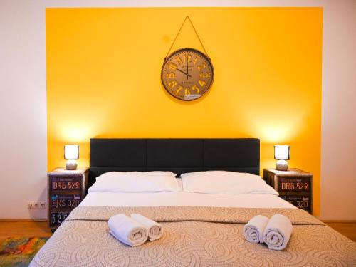 - une chambre avec un grand lit et une horloge murale dans l'établissement Backpacker Apartment Hofburg, à Vienne
