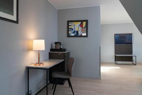 a desk with a lamp and a chair in a room at Quality Hotel Ålesund in Ålesund