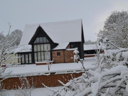 a house with a snow covered roof at Wortwell Hall Barn in Harleston