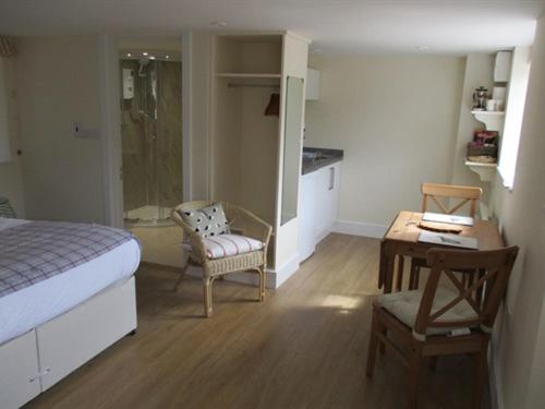 a bedroom with a bed and a chair and a table at The Red Barn in Long Wittenham