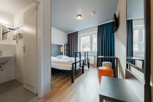 ein Hotelzimmer mit einem Bett und einem Badezimmer in der Unterkunft a&o Köln Dom in Köln