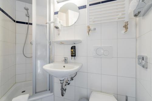 ein weißes Badezimmer mit Waschbecken und Toilette in der Unterkunft a&o Köln Dom in Köln