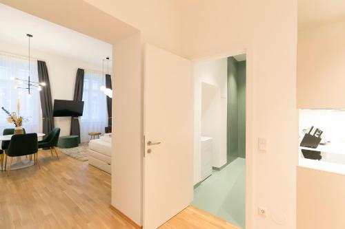 a white apartment with a dining room and a living room at Mint@Naschmarkt Premium Apartments in Vienna