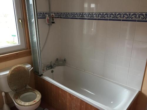 a bathroom with a toilet and a bath tub with a sink at Beautiful Highland 1-Bed Cottage in Inverness