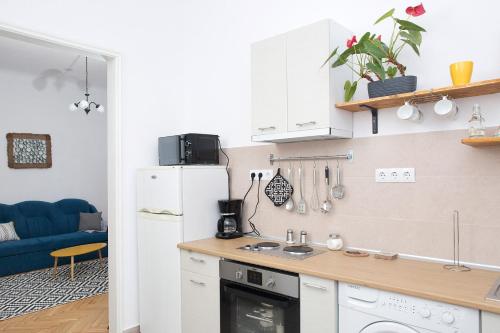 a kitchen with a white refrigerator and a blue couch at Spiegel Center in Oradea