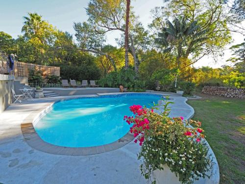 una piscina con flores en un patio en Waterland Lodge, en Hout Bay