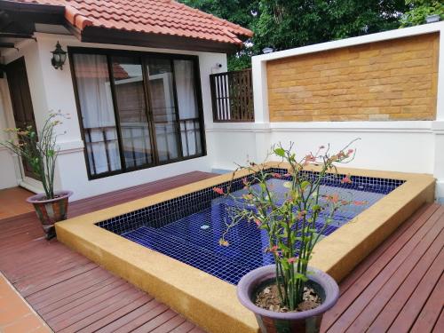 a small pool on a deck with two potted plants at Casa Khaoyai Bed&Breakfast in Mu Si