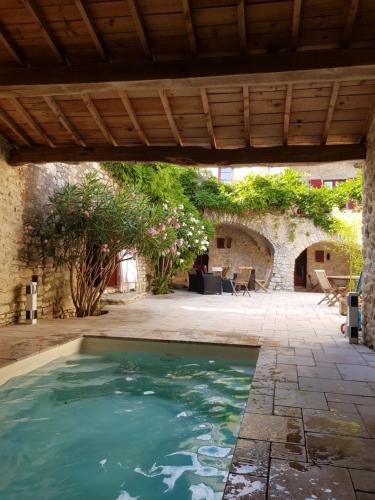 una piscina en un patio con techo de madera en Mas de Coulet en Brissac