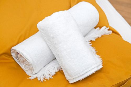 a pile of white towels sitting on a bed at Spiegel Center in Oradea