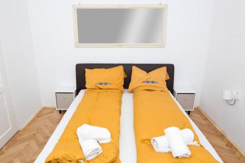 a bedroom with two beds with yellow sheets at Spiegel Center in Oradea