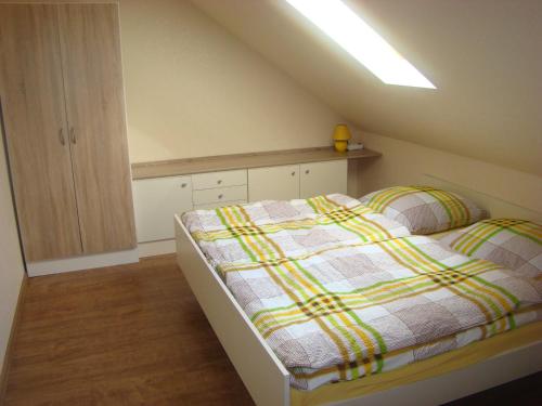 ein Schlafzimmer mit einem Bett mit einer gelben und grünen Decke in der Unterkunft Goldener Fuchs in Moschendorf in Gößweinstein