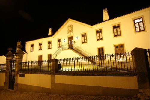 a large white house with a black fence at Solar de Chacim - Turismo de Habitação in Chacim