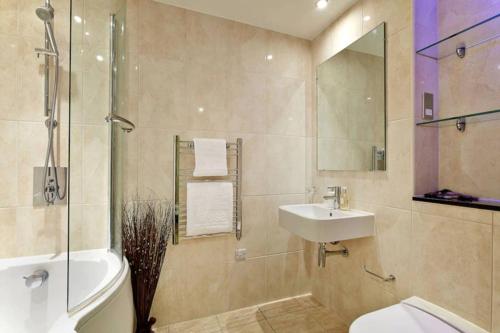 a bathroom with a sink and a toilet and a shower at MODERN APARTMENT at SLOUGH STATION, LONDON IN 18 MINS! in Slough