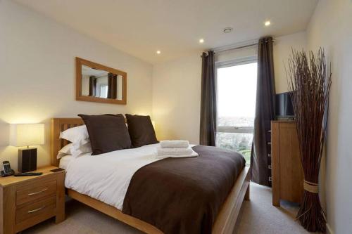 ein Schlafzimmer mit einem großen Bett und einem Fenster in der Unterkunft MODERN APARTMENT at SLOUGH STATION, LONDON IN 18 MINS! in Slough