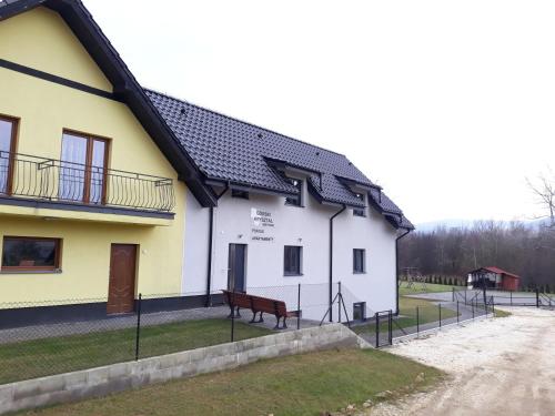 a white building with a bench in front of it at Górski Kryształ in Stronie Śląskie