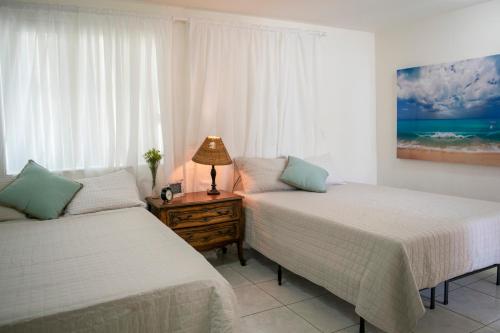een slaapkamer met 2 bedden en een tafel met een lamp bij Boho Studio in Little Havana - 5K in Miami