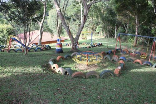 a park with a bunch of playground equipment in the grass at Estrela da Serra Hotel Fazenda in Santo Antônio do Pinhal