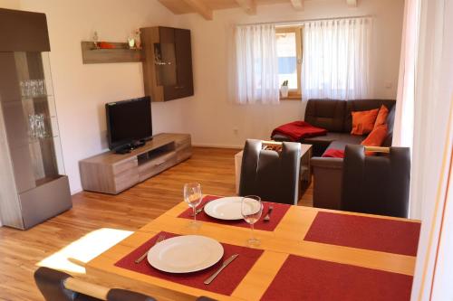 una sala de estar con una mesa y un sofá en Ferienwohnung Breyer Wiedemen, en Hopferau